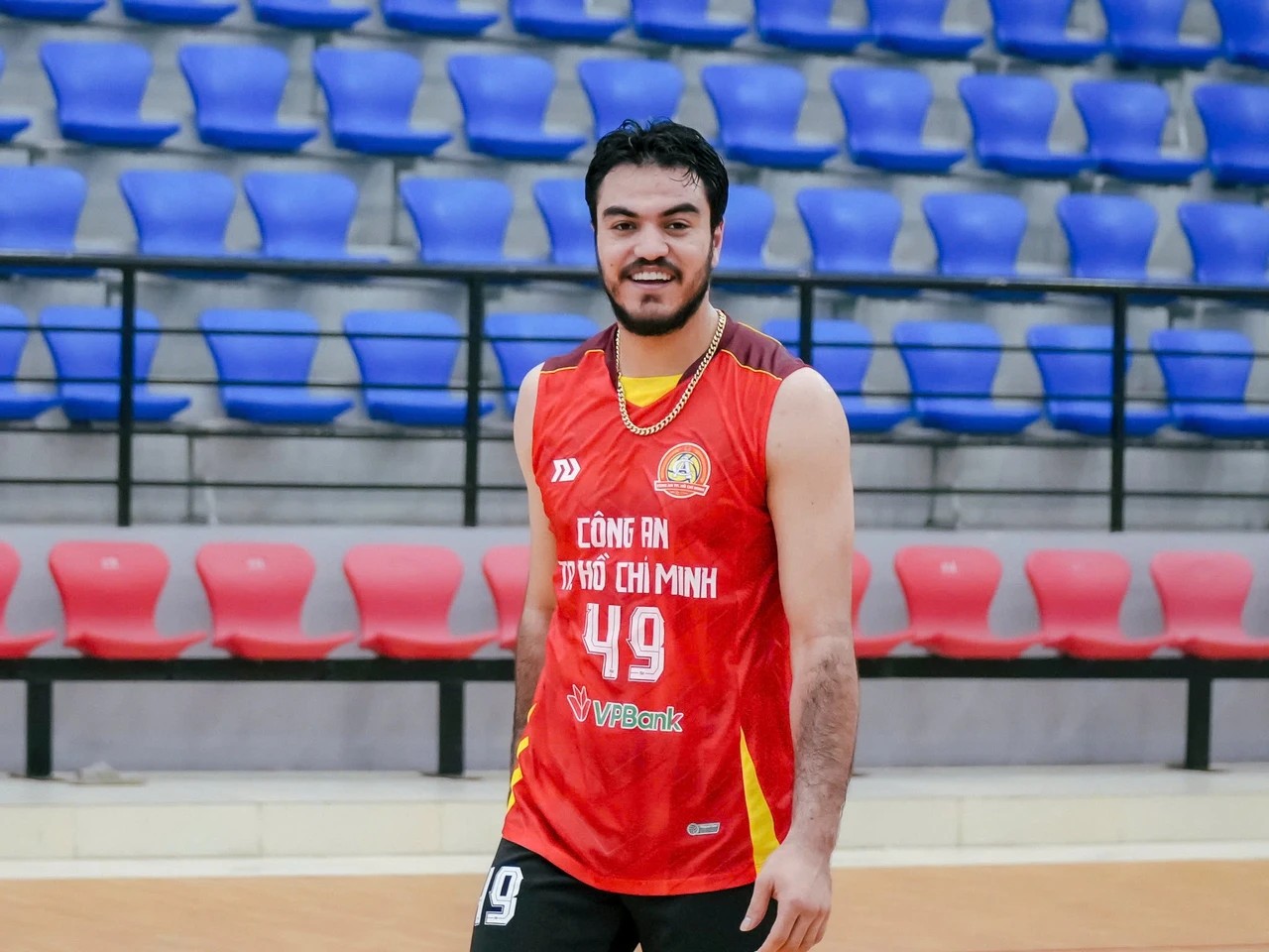 Morteza Sharifi mặc áo đỏ số 49 Công an TP.HCM đứng trước khán đài ghế xanh