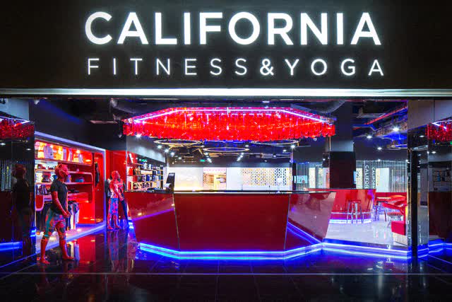 Mặt tiền một phòng tập California Fitness & Yoga với quầy lễ tân đỏ và biển hiệu lớn