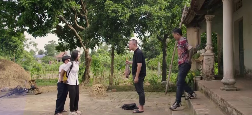 Thơ và Khang đứng ở sân nhà đối diện hai gã đòi nợ, một người cầm bật lửa và con gà