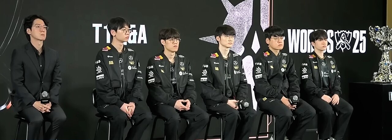 Đội hình T1 ngồi trả lời họp báo Media Day Worlds 2025, phía sau là cúp Summoner's Cup