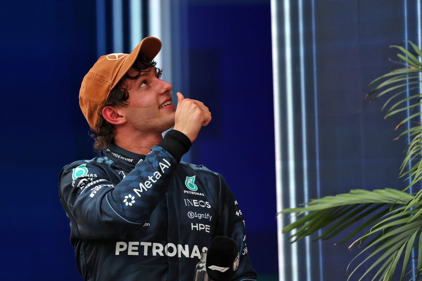 Kimi Antonelli đội mũ Mercedes giơ ngón cái cười trong khu paddock