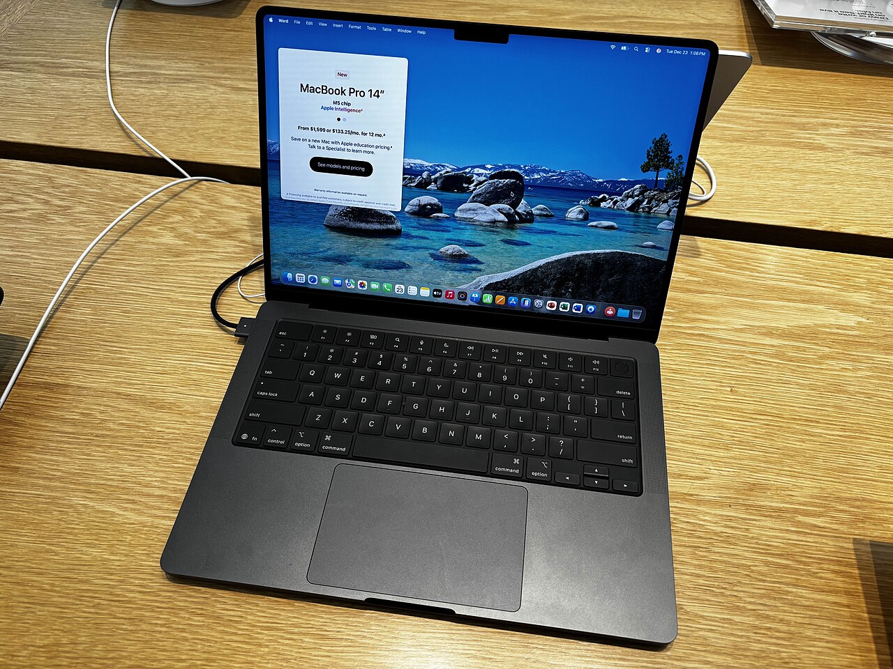 MacBook Pro 14 inch M5 màu đen không gian mở trên bàn gỗ tại Apple Store