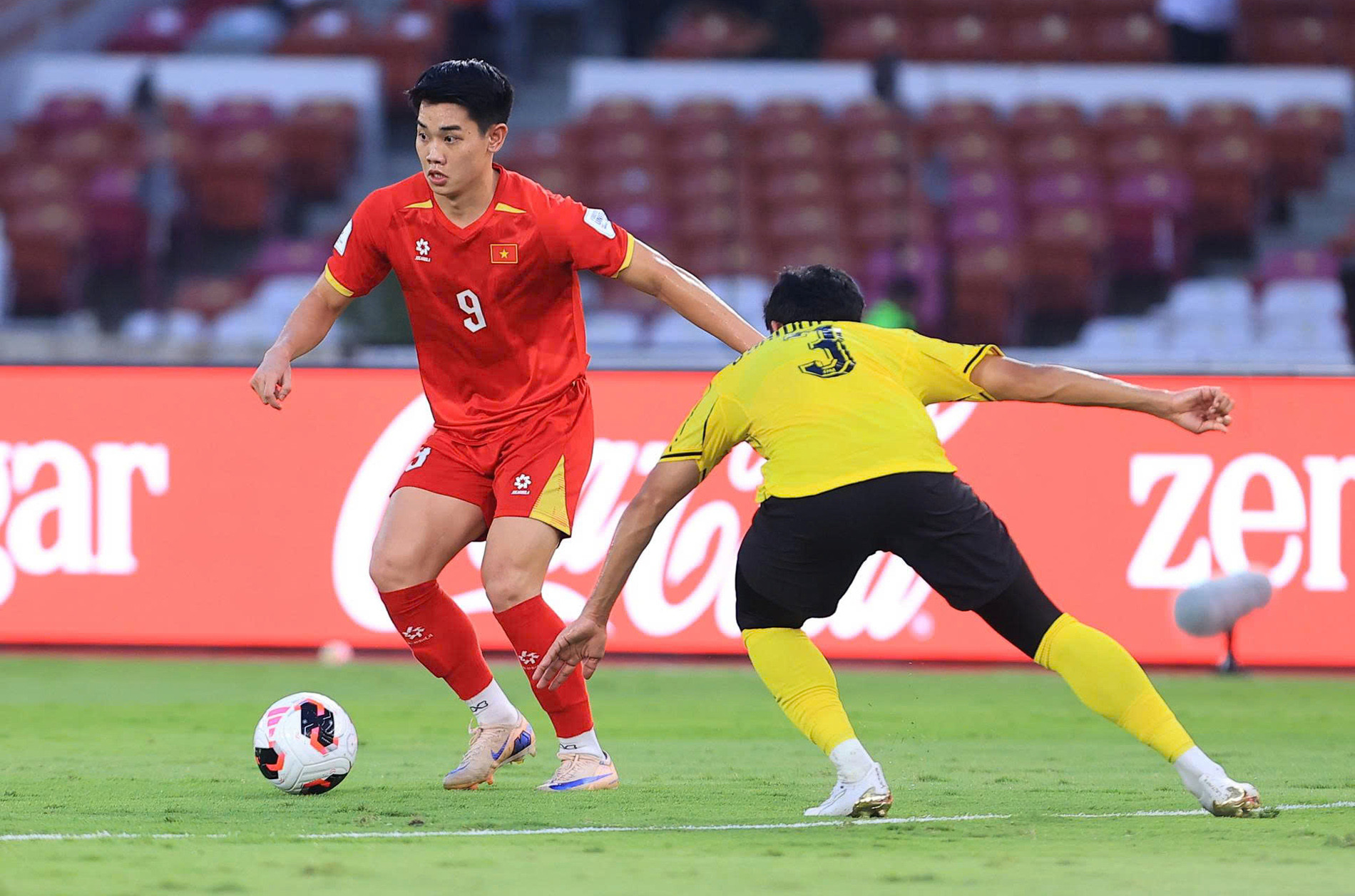 Nguyễn Đình Bắc số 9 đi bóng trước hậu vệ Malaysia trong trận tranh hạng ba FIFA ASEAN Cup 2026